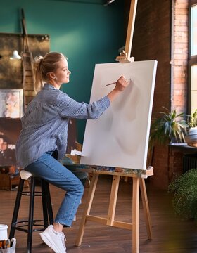 Mujer pintando con un lienzo en blanco al &oacute;leo en un estudio de pintura