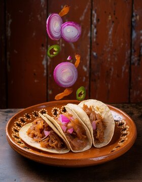 Tacos mexicanos con lima, cebolla morada y carne en un restaurante con decoraci&oacute;n mexicana con alimentos levitando