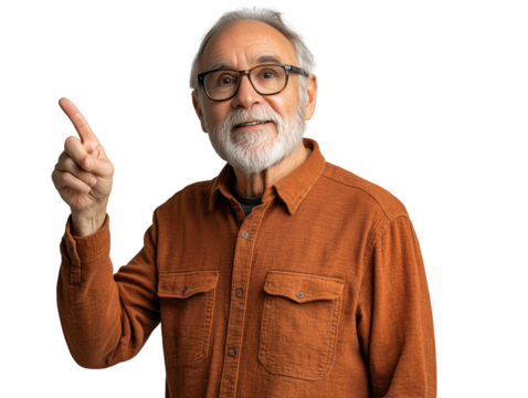 An elderly man with a gray beard and glasses is standing in a well-lit studio. He is wearing an orange button-up shirt and has a thoughtful expression on his face as he points upward.