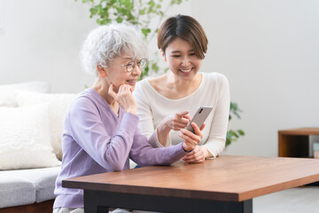 並んで座る若い女性とシニア女性