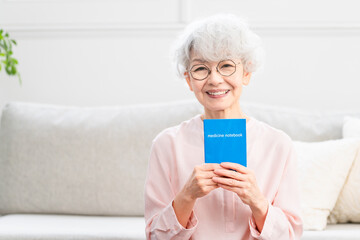 おくすり手帳を確認するシニア女性