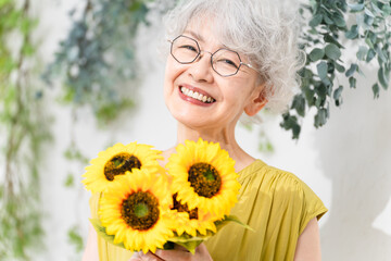 ひまわりを持つシニア女性