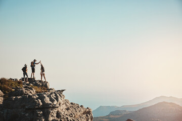 Friends, hiking and high five on mountain for fitness success, adventure view and backpack journey in summer. People, achievement and trekking together for cardio exercise, rock climbing and health
