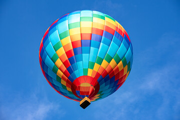 Obraz premium A colorful hot air balloon floating across the blue sky