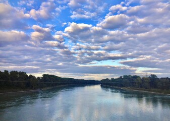 A beautiful formation of clouds above a river between the borders of austria and germany.