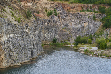 Rock formations in an abandoned quarry with a lake