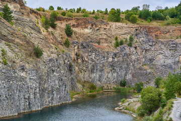 Rock formations in an abandoned quarry with a lake