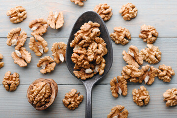 Old spoon with walnut kernels on wooden table close up. Food photography