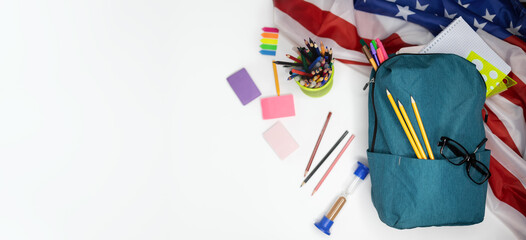 Top view flat lay banner backpack arranged on isolated white background blank circle for text or advertisement American flag. Concept: beginning of the school year back to school. Education in America