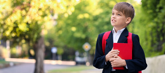 Cute little pupil after classes outdoors