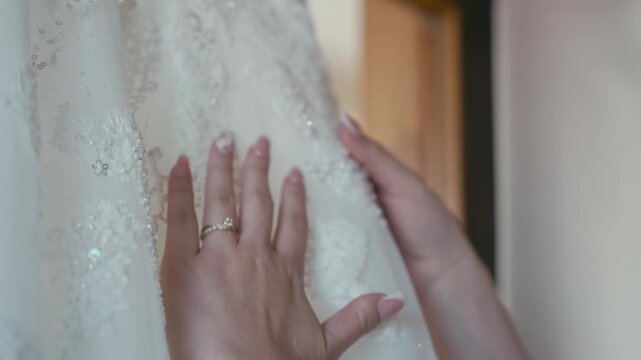 woman caressing wedding dress delicately