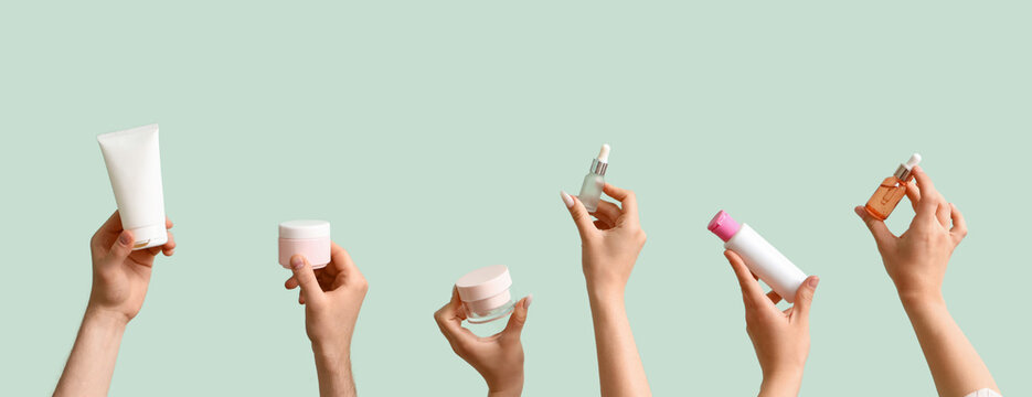 Women with cosmetic products on green background