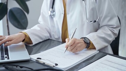 Doctor woman is working on laptop with medical reports. Healthcare professional reviews patient...