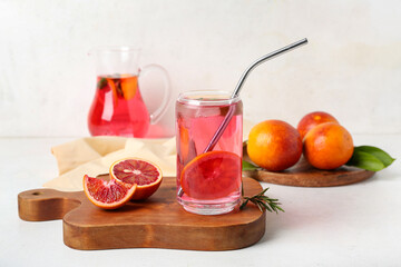 Glass of tasty blood orange lemonade on light background