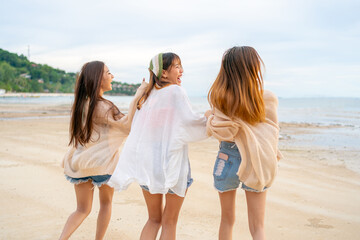  Group of Young Asian woman enjoy and fun outdoor lifestyle travel nature ocean on summer beach holiday vacation. Attractive girl friends walking and playing together at the sea on tropical island.