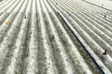 A fragment of a gray slate roof of an old sample made of asbeston