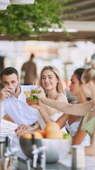 Happy,smiling young people, man and woman enjoying refreshing drinks, delicious cocktail in modern outdoor bar. Concept of friendship, party, leisure, celebration, relaxation