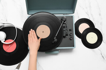 Woman with vinyl disks and record player on white background