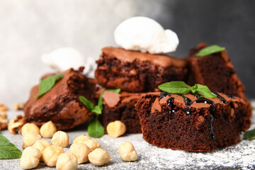 Pieces of tasty chocolate brownie with ice cream on grunge background