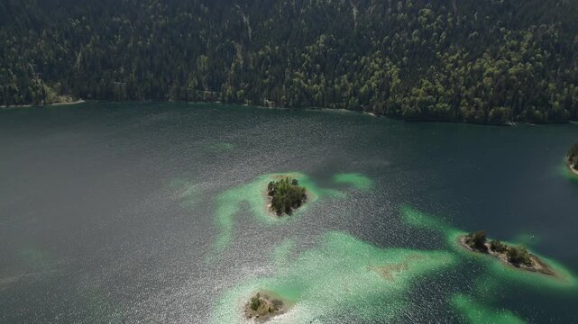 The unparalleled beauty of Lake Eibsee in Bavaria, Germany, surrounded by alps trees and mountains , clear sky. Flowing water with lagoons