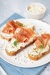 Plate of tasty bruschettas with jamon on light background