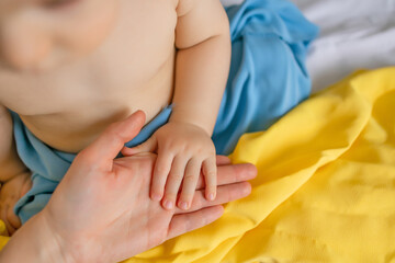 Baby Hand Holding Adult Hand with Ukrainian Flag Colors