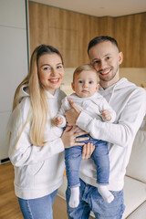 Happy Family Posing Together at Home in Casual Outfits