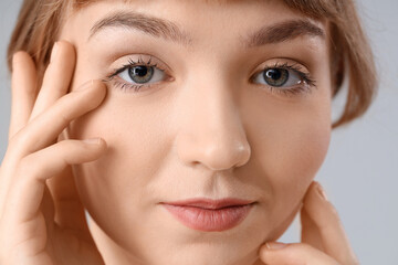 Obraz premium Beautiful young woman on light background, closeup