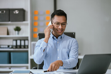 Businessman using laptop computer in office. Happy man, entrepreneur, small business owner working online.