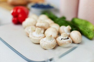 raw champignon on a cutting board on a white kitchen