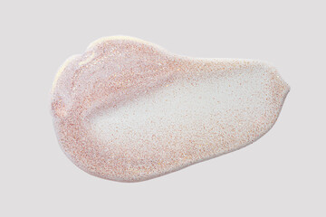Lip gloss or oil gel with pink shimmer texture smudge on gray isolated background