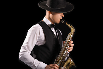 Male artist playing saxophone on black background