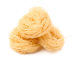 Tasty raw pasta nests on white background