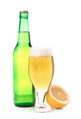 Bottle and glass of fresh light beer with lemon on white background