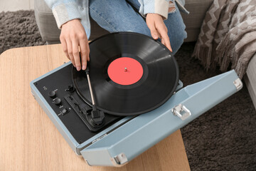 Woman using record player in room, closeup