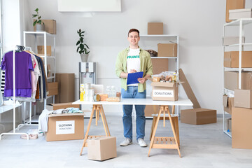 Male volunteer with clipboard and donations in center