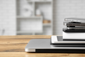 Stack of modern gadgets on wooden table in workshop