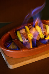 Flaming a Pineapple with Bacon Skewered in a Restaurant table, Braga, Portugal.