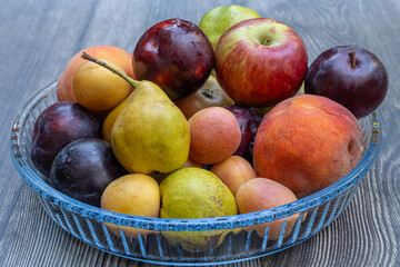 Fruit plate, pear, peach, red plum, apricot, apple. Seasonal fruits.