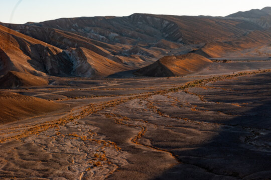 Expanse of dry, barren Arava Desert at sunset in southern Israel.