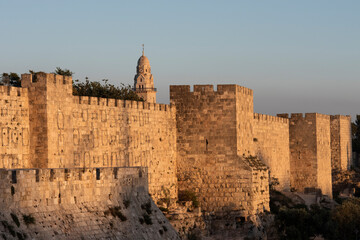 The walls of the Old City of Jerusalem bathed in a golden glow at sunset in Israel. © Yehoshua Halevi