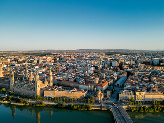 Obraz premium Spectacular Zaragoza city skyline at sunset. View of old town center, Cathedral of Zaragoza and Ebro River. Medieval and historic travel destination in Aragon - Spain. Sunset point, orange reflections