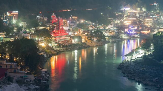 Dusk to night timelapse showing Hindu temples on the banks of the sacred Ganges river in Rishikesh, Uttarakhand, India.