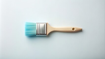 A solitary, soft-bristled light blue paintbrush lies horizontally on a clean, crisp white background, awaiting artistic creation, evoking feelings of serenity and inspiration.