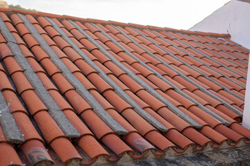 A close up of a tiled roof with rows of terracotta tiles