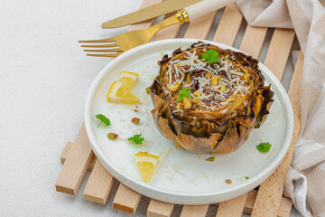Delicious baked artichoke with parmesan cheese and pistachio. Olive oil, garlic, parsley and lemon