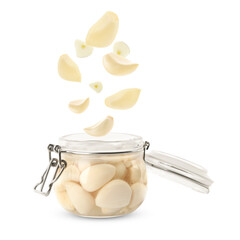 Jar with pickled garlic and cloves falling into it on white background