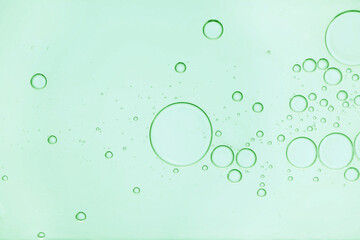 Green cosmetic oil with bubbles, closeup view
