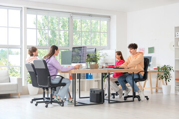 Team of programmers working at table in office