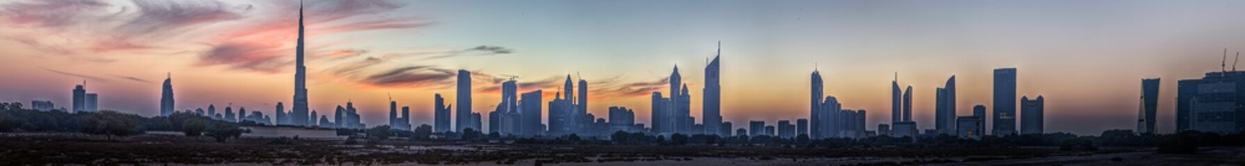 Obraz premium Panoramic image of the illuminated skyline of Dubai at dusk after sunset